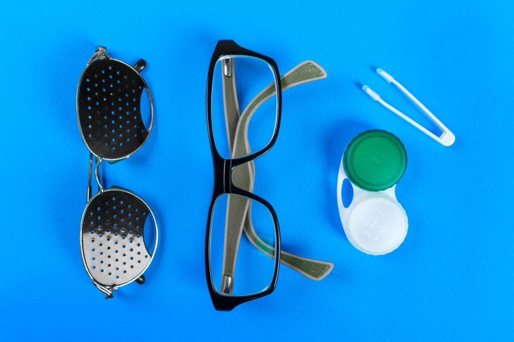 A set of accessories for sight. including Pinhole glasses and normal eyeglasses and lenses