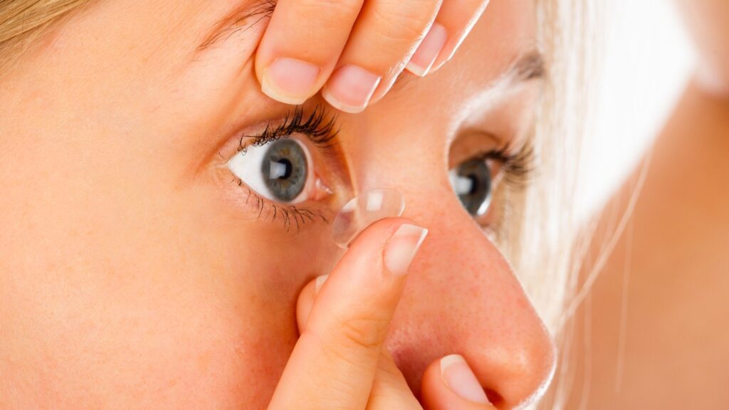 Close up shot of a young woman putting on her soft contact lens edited