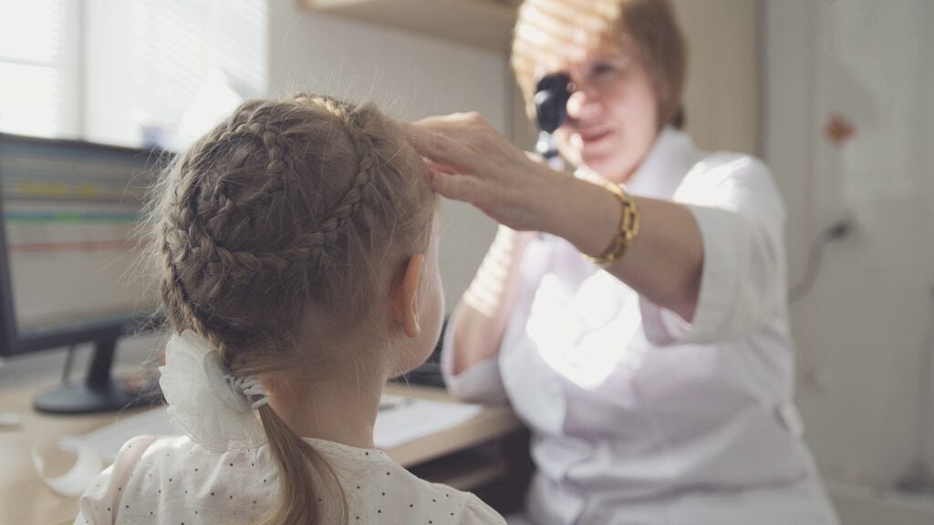 female optometrist checking child in her clinic