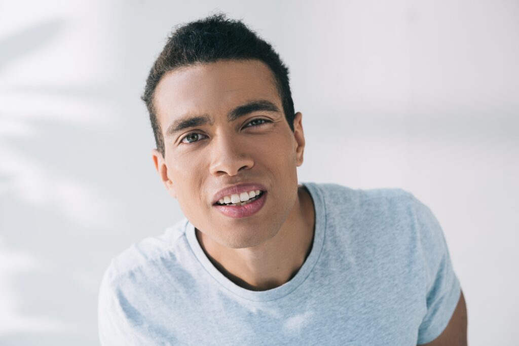 Mixed muscular man winking while facing camera