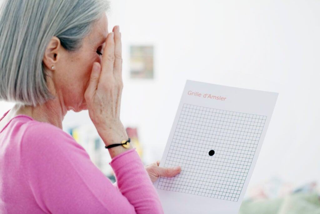 Older woman undergoing Amsler grid as a way of diagnosing AMD