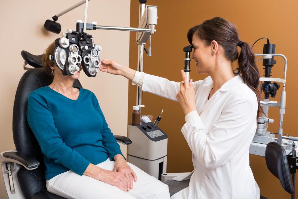 Optometrist Examining Senior Womans Eyes using a Retinoscope