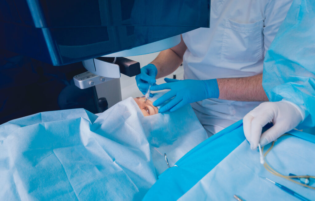 Patient and team of surgeons in operating room during ophthalmic surgery