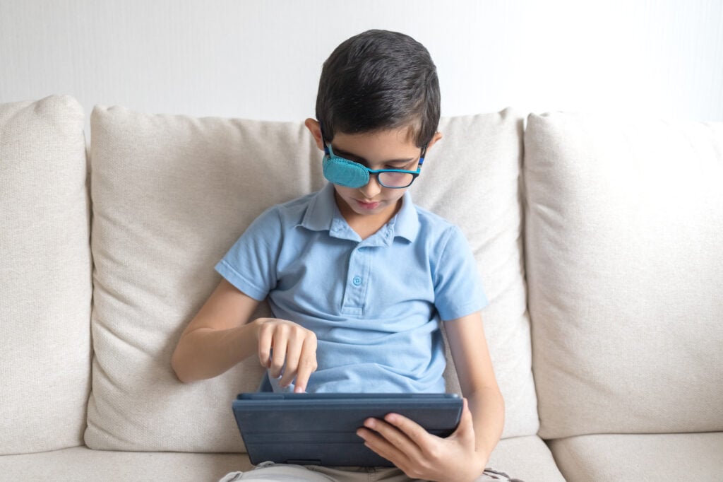 Portrait of boy in glasses with amblyopia patch for glasses