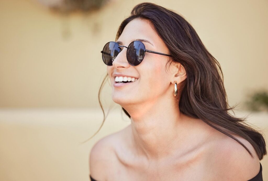 smiling cheerful mixed race woman wearing sunglasses