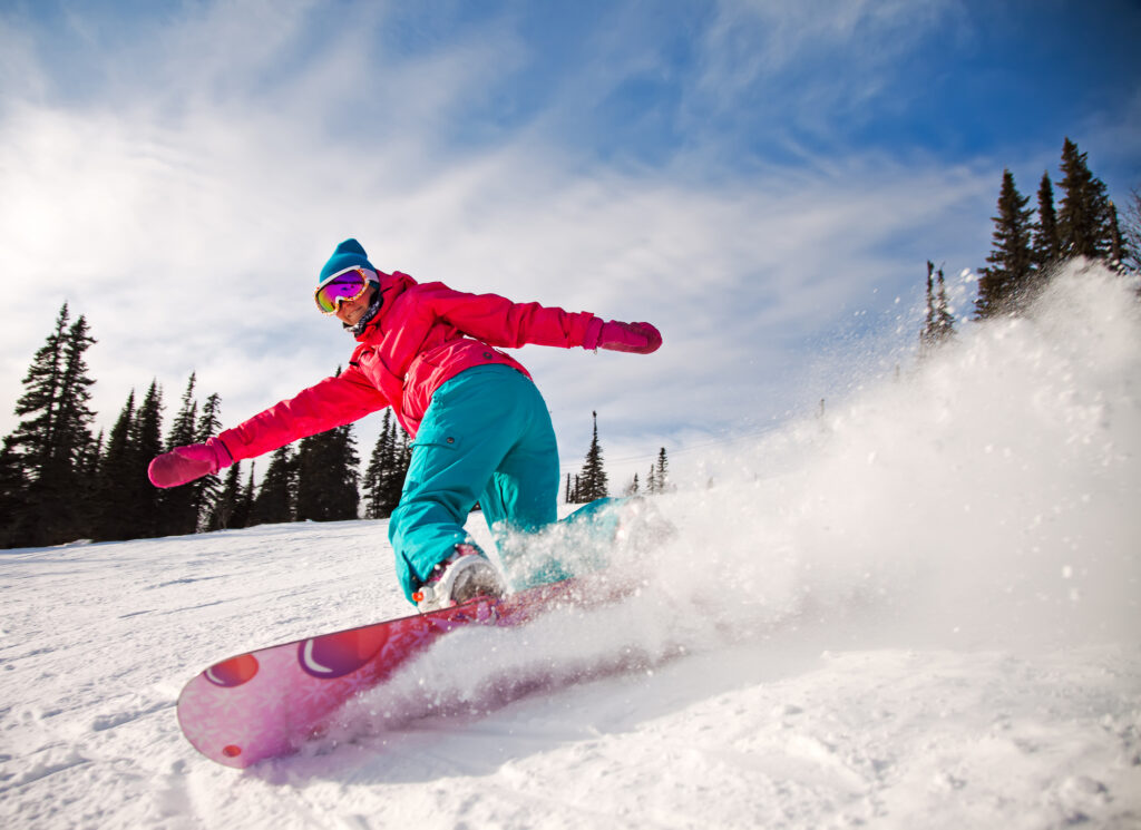 Snowboarder jumping through air with deep blue sky in background