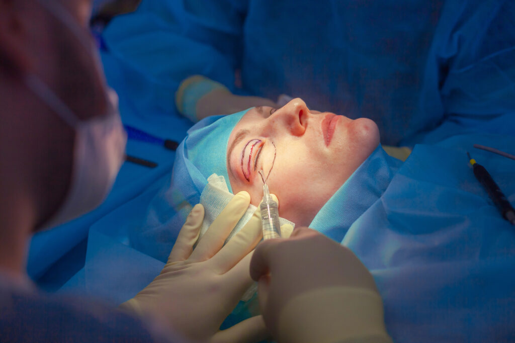 Surgeon inserts an injection into the upper eyelid of the patient