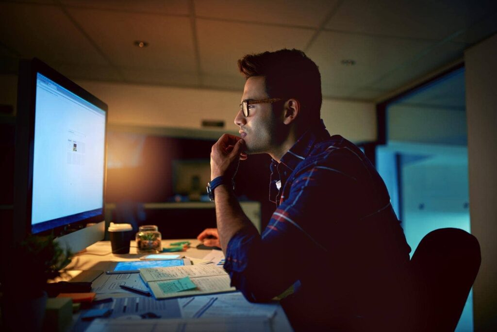 young businessman using computer for work during the night